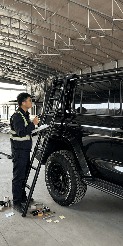 Technician inspecting an installed exterior accessory on a black SUV