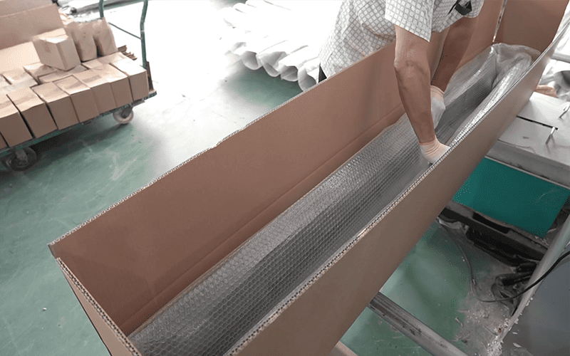 Worker preparing protective packaging for an automotive exterior part