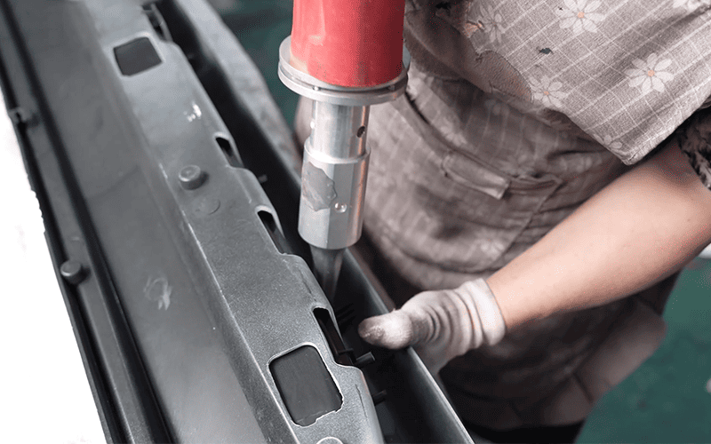 Worker fastening an automotive exterior component during fitment analysis