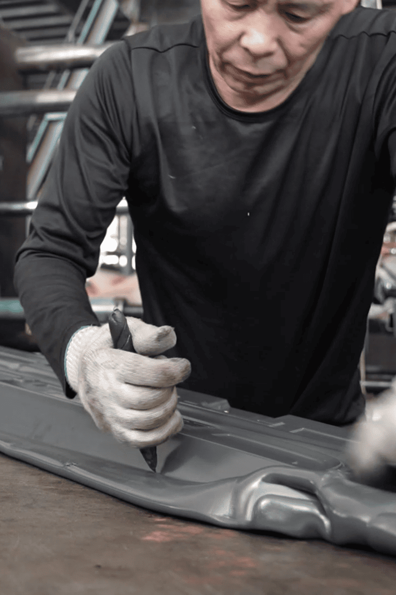 Worker preparing an automotive exterior part in the Yuxuan factory