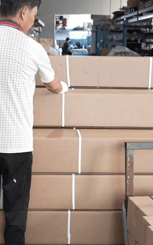 Worker checking strapped cartons before shipment