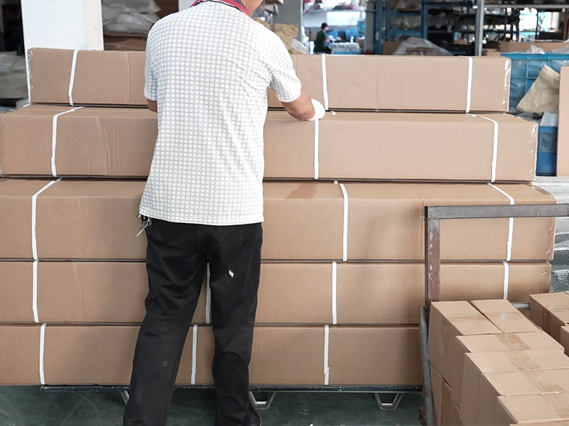 Worker securing stacked cartons for an automotive exterior parts order