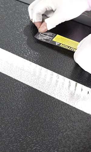 Gloved hands applying a product label during quality review