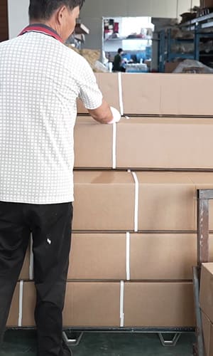 Worker securing stacked cartons for product packaging