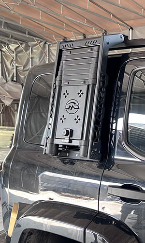 Black vehicle side ladder installed on an SUV body