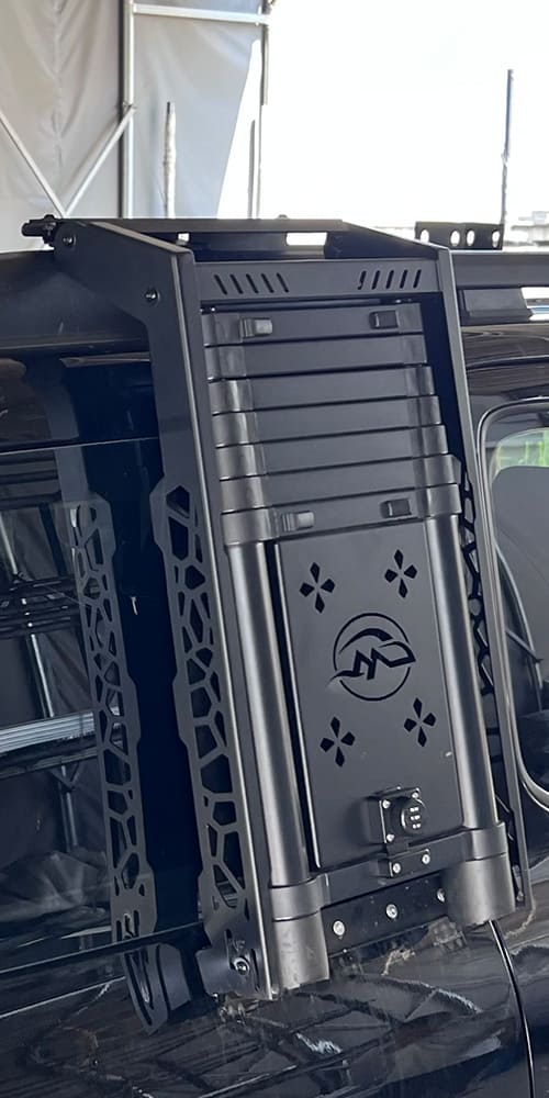 Close view of a black vehicle side ladder installed on an SUV