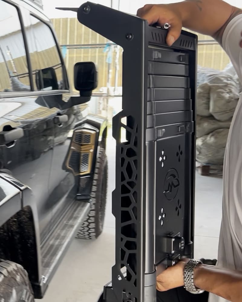Technician holding a vehicle side ladder beside the SUV mounting area