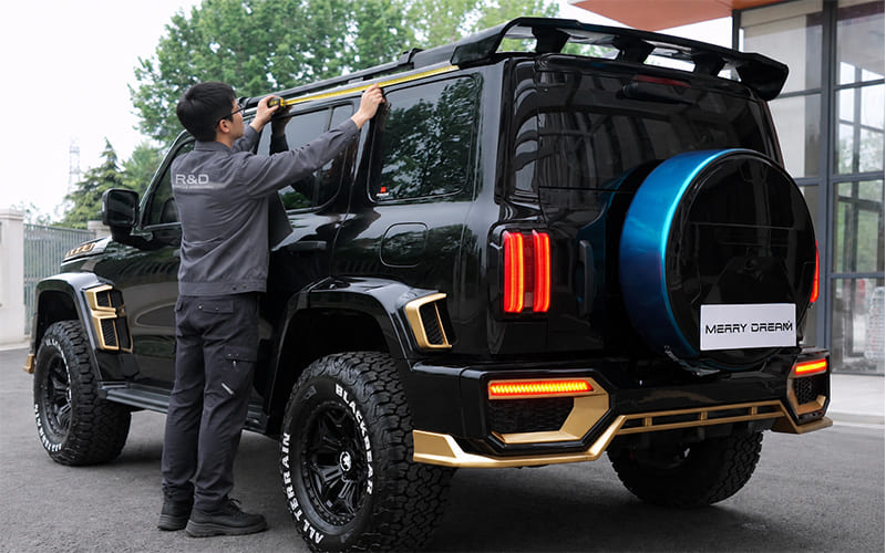 Technician measuring the upper side of an SUV body